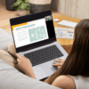 Woman on a couch looks at her laptop with the screen displaying reflection questions to help her identify the influences on her life.