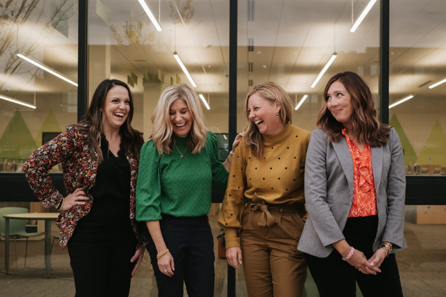 Four women laughing outside a library