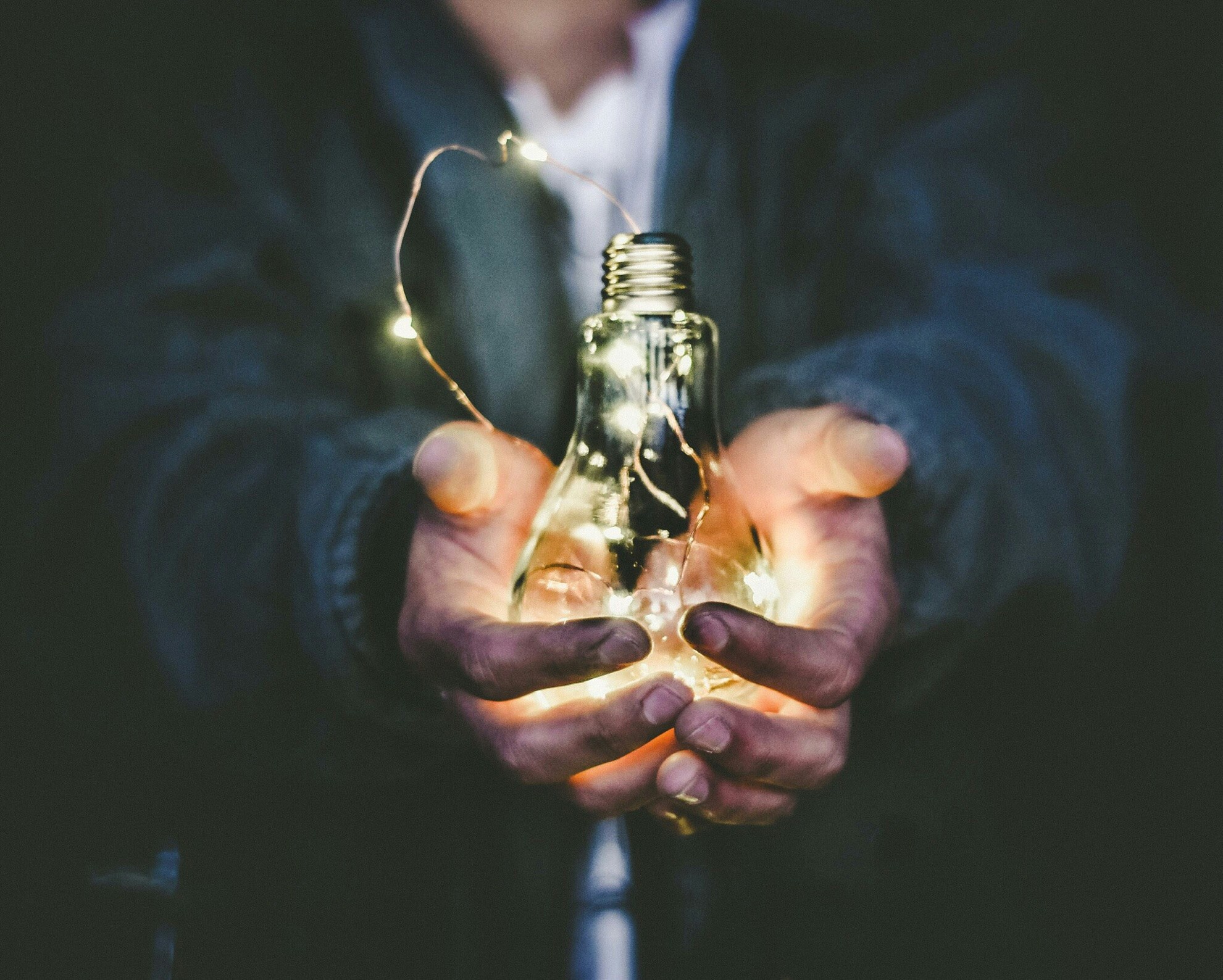man holding a glass light bulb