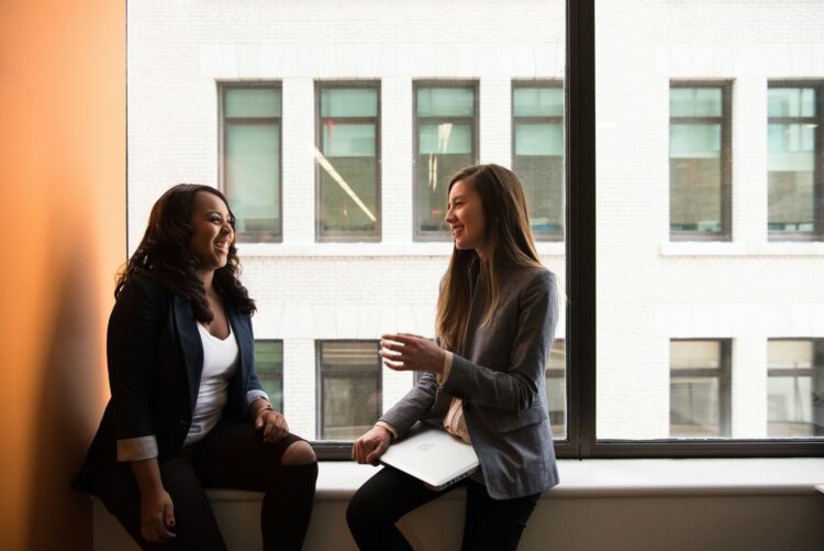 Two Women Discussing Work and Smiling