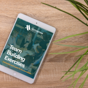 Team Building Exercises Digital product cover pictured on an ipad as it lays on a table with a plant nearby