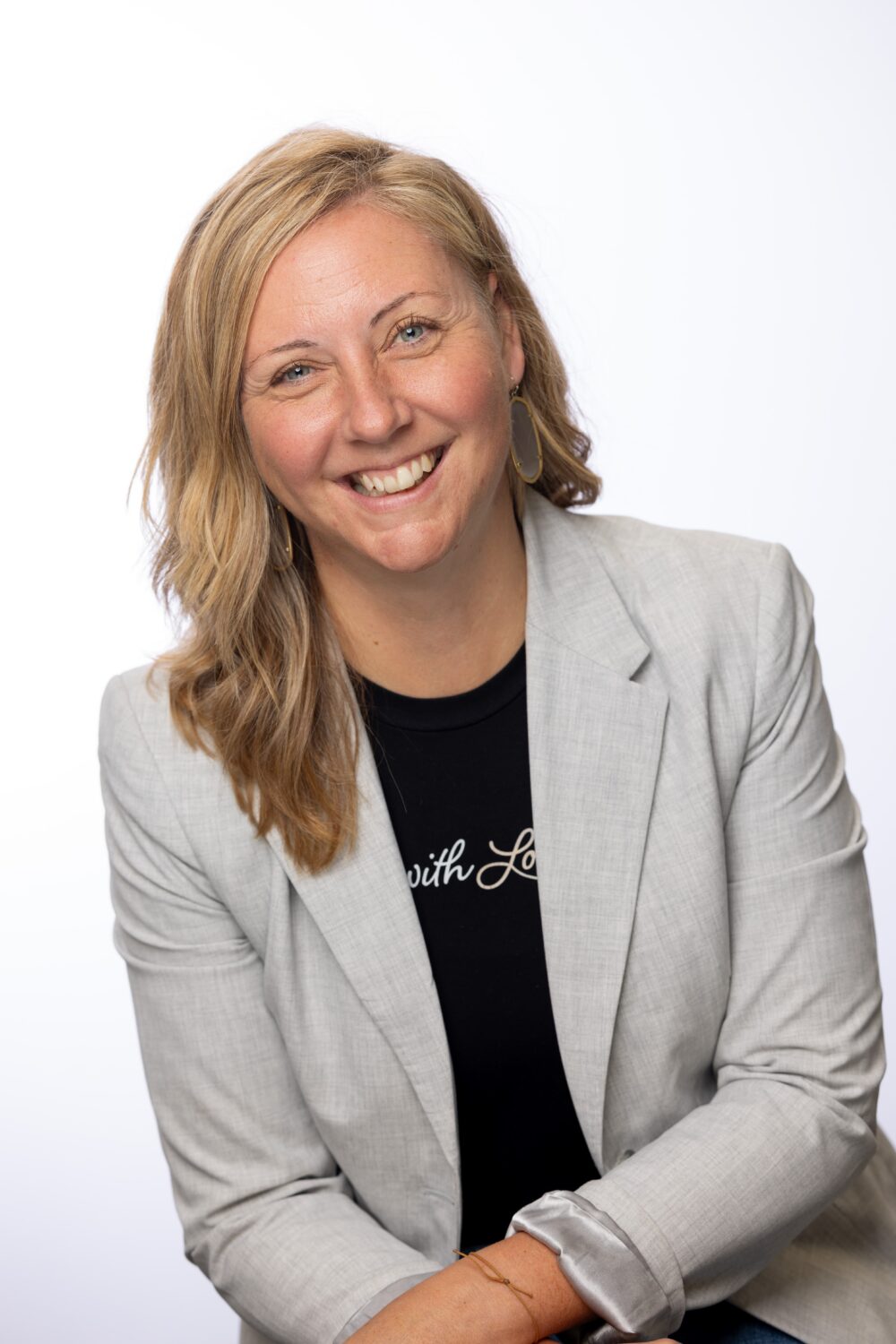 A professional women looks directly at the camera, smiling.
